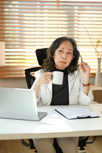 Attractive Mature Businesswoman Drinking Hot Tea Working Laptop Her Workstation — Stockfoto