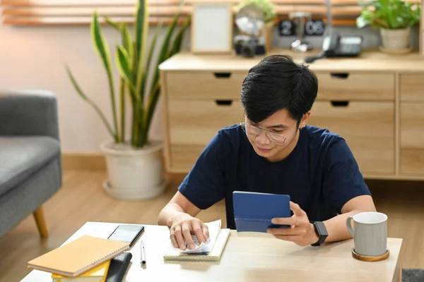 Young asian male using calculator for calculating money bank loan rent payments, managing expenses finances.