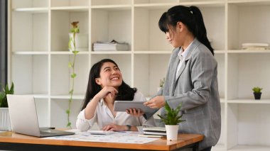 Two business colleagues sharing business ideas, discussing for new strategy of development at corporate office.