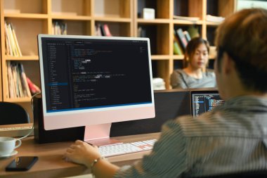 Team of software development brainstorming, working with coded data in corporate office. Programming and coding technologies concept.