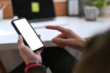 Close up view man sitting in his home office and using mobile phone. White screen for your advertise text.