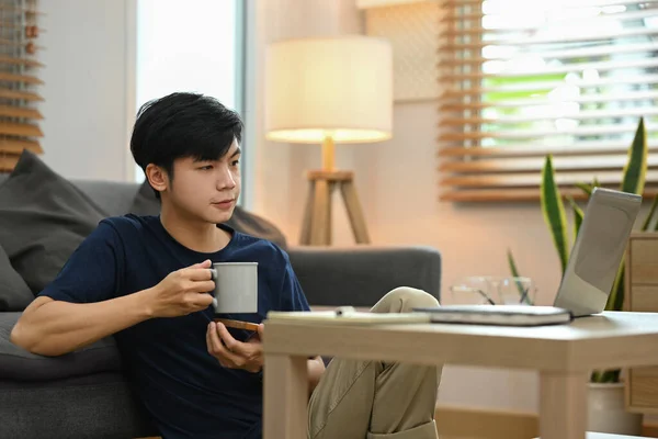 Casual Asian Male Drinking Coffee Reading Online News His Laptop — 스톡 사진