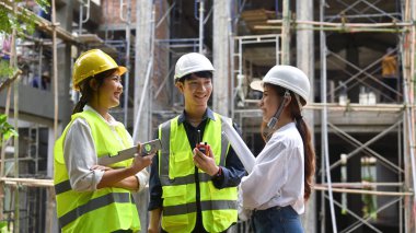 Shot of two female architect discussing with male engineer manager about construction project.