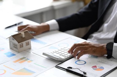 Mal investors hand using calculator for calculating loan of finance and planning for real estate investment.