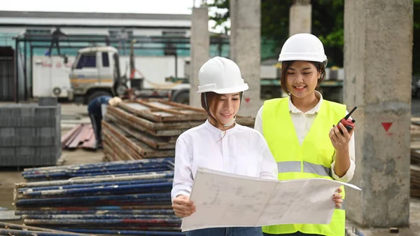 Two Young Architects Wearing Safety Helmet Vest Inspecting Industrial Building — Stockfoto