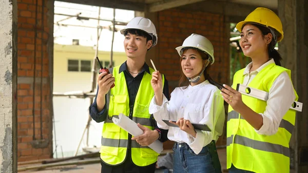 Civil engineers and specialists working, checking plan together at construction site. Industry, Engineer, construction concept.