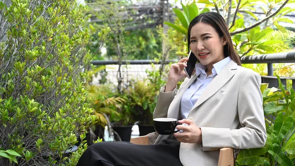 Smiling Young Businesswoman Having Phone Conversation While Sitting Outdoors Cafe — 스톡 사진
