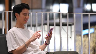 Positive hipster man chatting online, messaging on mobile phone. Technology, social network, communication concept.