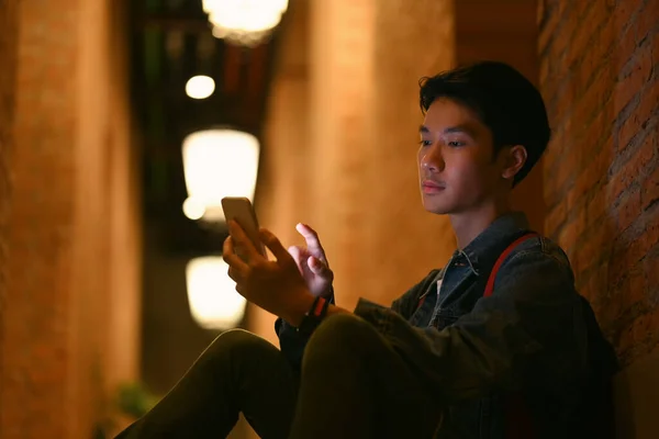 Young Man Using Mobile Phone While Sitting Stairs Night City — Zdjęcie stockowe