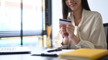 Cropped view of happy young woman holding credit card. Online shopping, e-commerce concept.