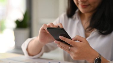 Cropped view of view woman hand typing text message, chatting online on smart phone.