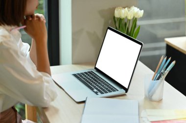 Cropped images of young woman entrepreneur sitting front of laptop and thinking about her business plan.