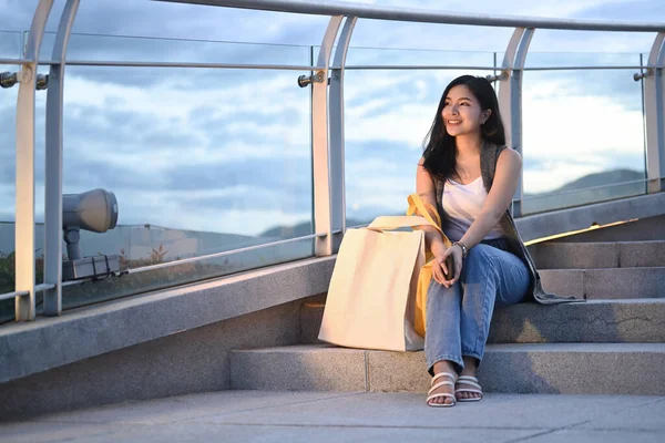 Charming Asian Woman Shopping Bags Sitting Terrace Modern Building Overlooking — Stok fotoğraf