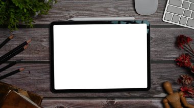 Mock up digital tablet with white screen, stationery and wireless keyboard on wooden table. Top view, Flat lay.