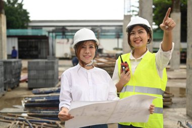 Female architects and inspectors supervising progress of construction project together. Industry, Engineer, construction concept.