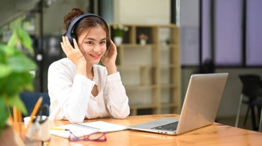 Professional businesswoman using laptop and working with document on office desk.