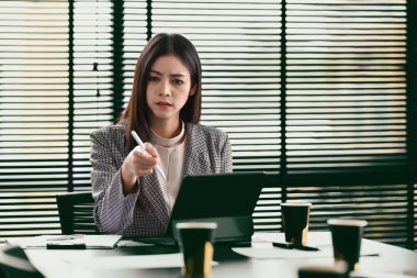 Professional businesswoman using laptop and working with document on office desk.