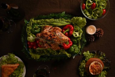 Above view of homemade roasted turkey or chicken at festive Christmas or Thanksgiving table with all the sides.