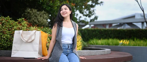 Happy Asian Woman Shopping Bags Sitting Bench Park — Stok fotoğraf