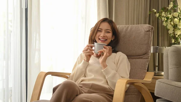 Cheerful Woman Wearing Sweater Drinking Hot Coffee Comfortable Armchair Home — Foto Stock