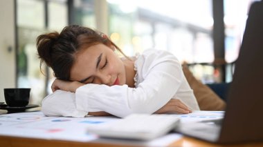 Kadın ofis çalışanı işten yorgun, iş ilhamı yok, kafası ofis masasında yatıyor..