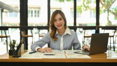 Parlak modern şirket ofisinde dizüstü bilgisayar kullanan güzel bir bayan çalışan..