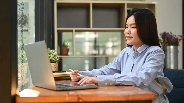 アジアの女性オフィスワーカーは 彼女のラップトップコンピュータ上でオンライン情報を検索したり ビジネスメールを入力します — ストック写真