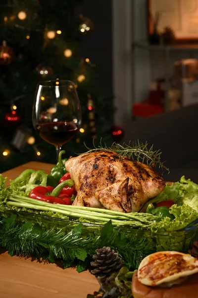 Homemade roasted turkey on Thanksgiving table or Christmas dinner by candlelight in a decorated room with a Christmas tree.