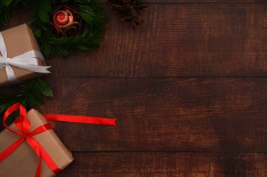 Noel hediye kutuları ve tahta arka planda köknar ağacı dalı. Düz konum, üst görünüm ve metin için boşluk kopyala.