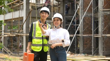 Endüstriyel inşaat sahasında güvenlik kaskı takan iki memnun mühendis. Endüstri, Mühendis, inşaat konsepti.