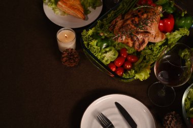 Şükran Günü masası ev yapımı kavrulmuş hindi ile servis edilir, mum ve çam kozalaklarıyla süslenir. Kopyalama alanı olan üst görünüm.