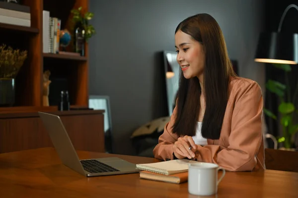 Happy businesswoman reading good news, business email on laptop, working in personal office.