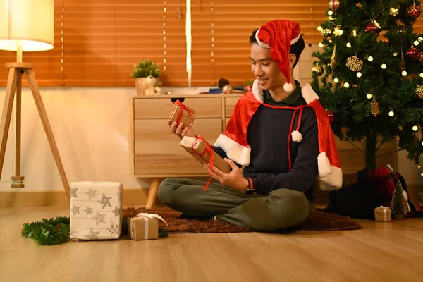 Surprised man with Christmas gifts and sitting in decorated room for celebrating New year and Christmas festive.