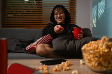 Uzaktan kumandalı mutlu adam oturma odasında tiyatro filmi izliyor. Boş zaman aktivitesi, rahatlama, hobi konsepti..