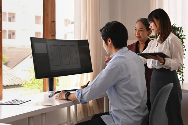 Üst düzey kadın takım lideri ve genç yaratıcı insanlar ofiste fikir uygulaması yazılım tasarımı projesini tartışıyor.