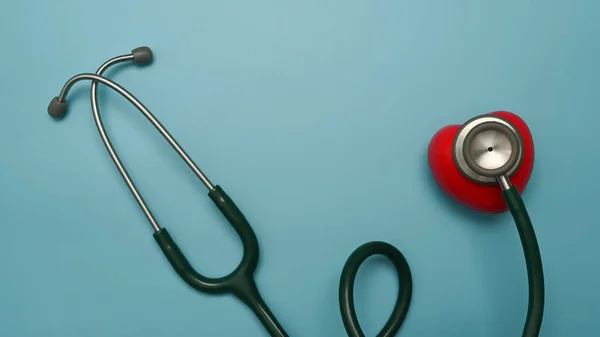 青い背景に聴診器と赤い心臓 心臓病 生命保険の概念 — ストック写真