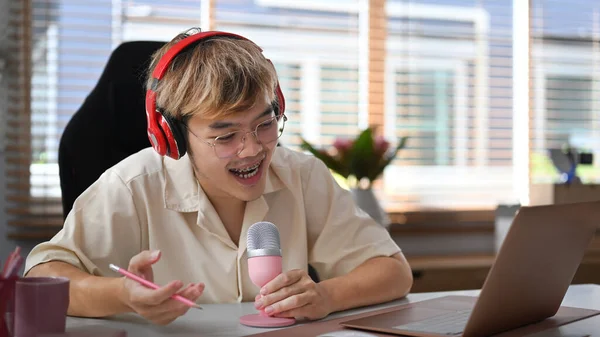 Χαρούμενος Νεαρός Ασιάτης Που Χρησιμοποιεί Φορητό Υπολογιστή Και Μικρόφωνο Streaming — Φωτογραφία Αρχείου