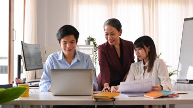 Modern ofiste mobil uygulama yazılım tasarımı projesinde işbirliği yapan geliştirici ekibinin resmi.