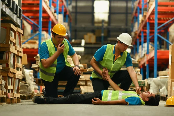 재봉사들은 콘크리트 바닥에 의식을 채누워 동료들을 부상자들에게 응급처치를 있습니다 — 스톡 사진