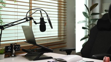 Profesyonel yoğunlaştırıcı mikrofon, dizüstü bilgisayar ve kulaklıkla ev yapımı podcast. Teknoloji ve ses ekipmanları kavramı.