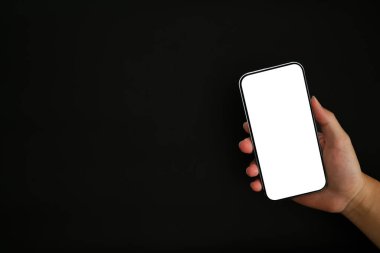 El ele tutuşmanın yakın görünümü siyah arkaplanda boş ekran izole edilmiş akıllı telefonu taklit et.