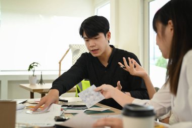 Bir grup insan inşaat planlarını tartışıyor, modern ofis planlarıyla doğal güneş ışığı altında çalışıyorlar..