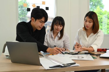 Mimarlardan oluşan profesyonel bir ekip beyin fırtınası yapıyor, yeni proje üzerinde birlikte çalışıyor ve modern ofiste çizimler yapıyor..