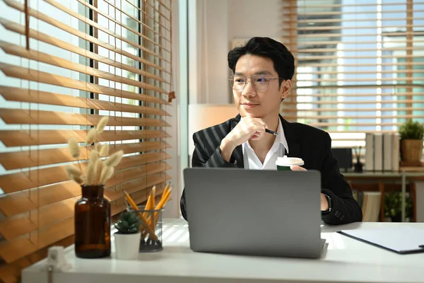 Przemyślany Azjatycki Inwestor Formalne Ubrania Siedzący Przed Laptopem Patrzący Przez — Zdjęcie stockowe