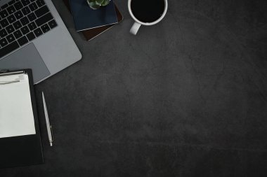 Laptop bilgisayarı, not panosu, kahve fincanı ve ev bitkisi olan modern bir iş yeri. Kopyalama alanı olan üst görünüm.