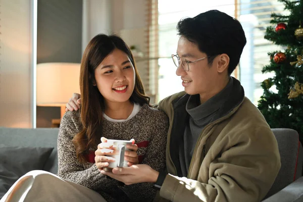 ロマンチックな若いカップルはソファでリラックスし コーヒーを飲み 自宅でクリスマスの朝を楽しむ — ストック写真