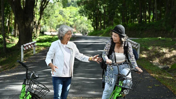 Güzel Bir Günde Parkta Bisikletle Yürüyen Iki Olgun Kadın Emekliler — Stok fotoğraf