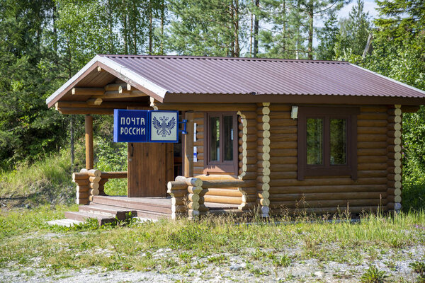 Рускеала, Россия - 10 июля 2021: Деревянный дом с вывеской "Почта России" на русском языке на фасаде