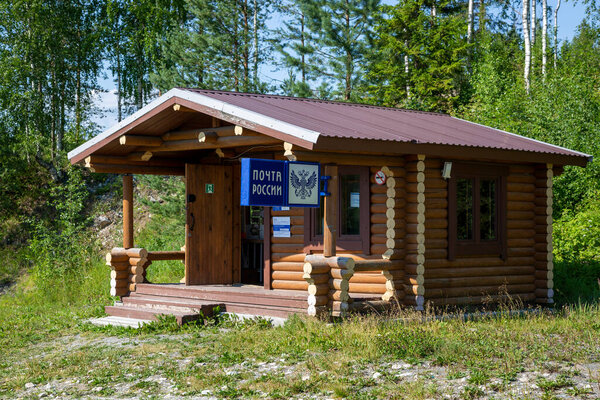 Рускеала, Россия - 10 июля 2021: Деревянный дом с вывеской "Почта России" на русском языке на фасаде