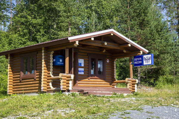 Рускеала, Россия - 10 июля 2021: Деревянный дом с вывеской "Почта России" на русском языке на фасаде